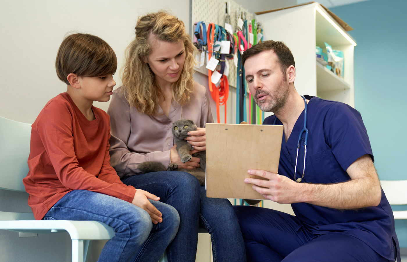 Doctor explaining something to a child and his mother in a clinic setting